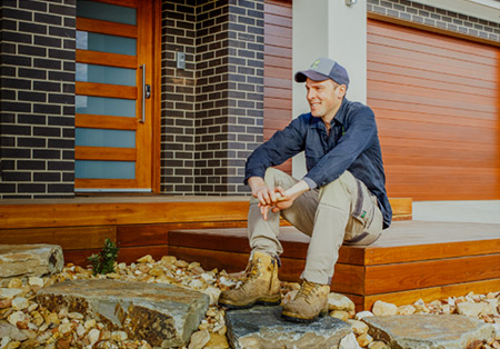 A photo of Taylored Gardens Owner George Taylor sitting on the steps of one of his gardens